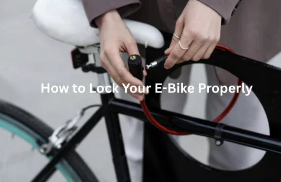 Person securing black electric bike with red cable lock around frame, side view