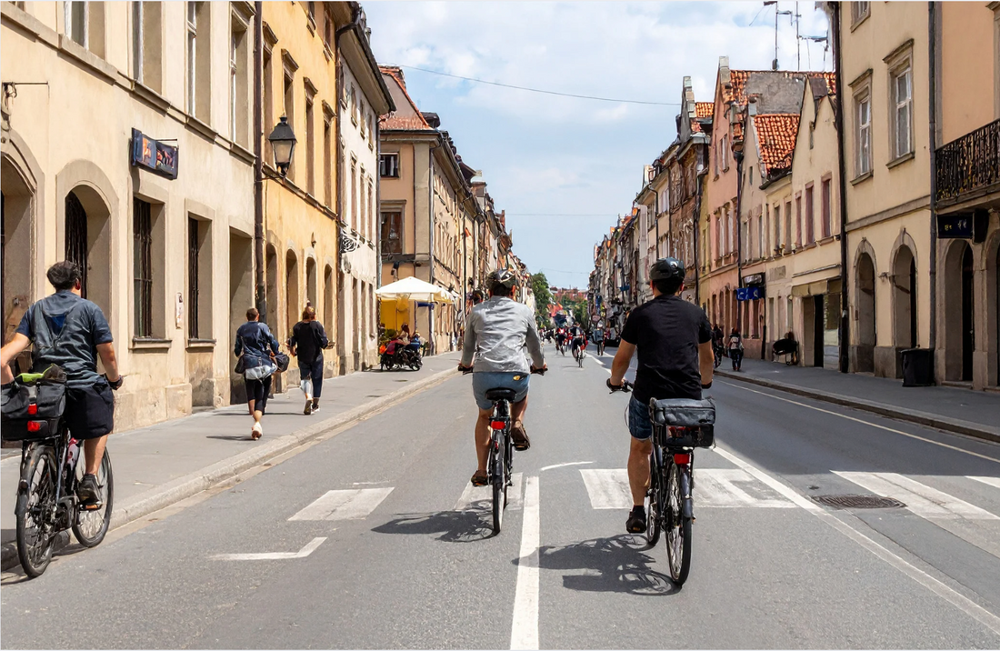 Electric bikes ridden on a city street, rear view with urban buildings and cyclists