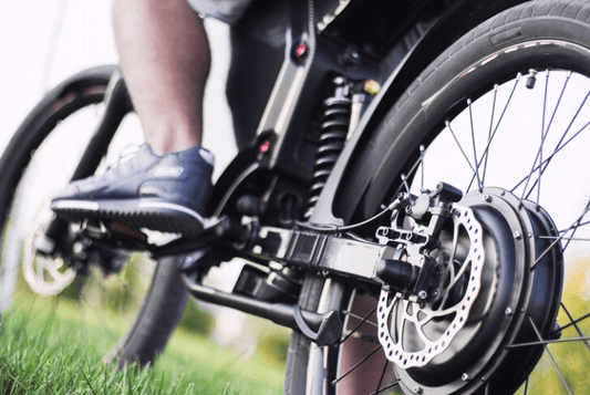 Electric bike rear wheel motor and disc brake close-up on grass