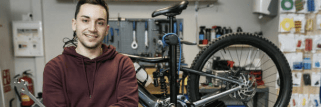 Man in workshop with electric bike, displaying e-bike maintenance at Pogo Cycles store